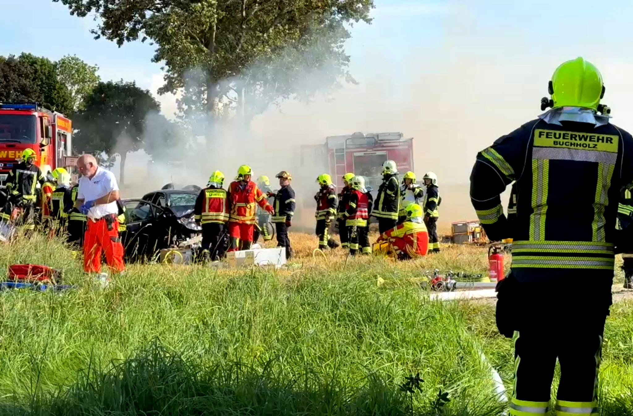 Unfallfahrzeuge, Rettungskräfte, abgesperrte Straße, Blaulicht.